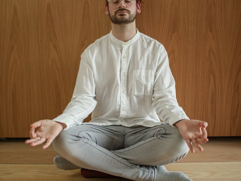 Close-up of a calm person practicing mindfulness in a sunlit room.